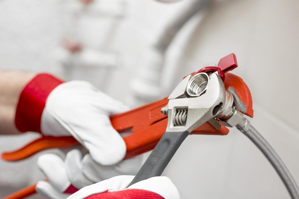Plumber holding pipe wrenches for an emergency repair in Spring Valley