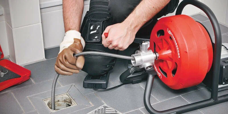 Plumber using a drain-cleaning machine in Spring Valley