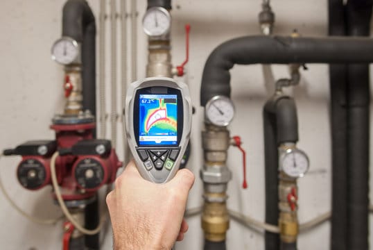 Plumber using a thermal imaging camera to inspect pipes in Spring Valley