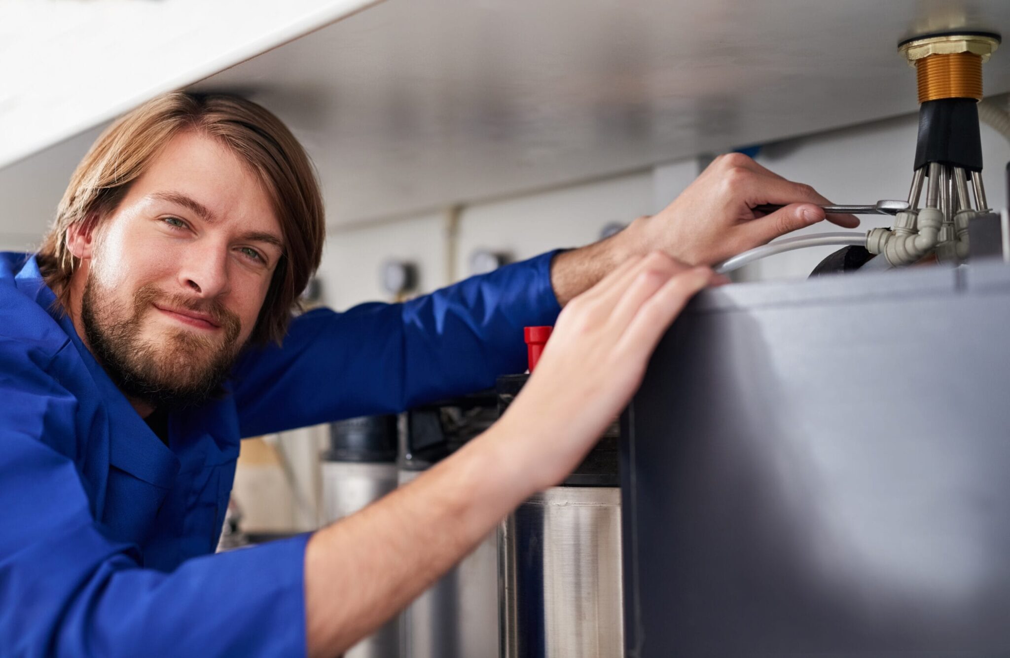 Technician servicing a residential water heater tank in Spring Valley